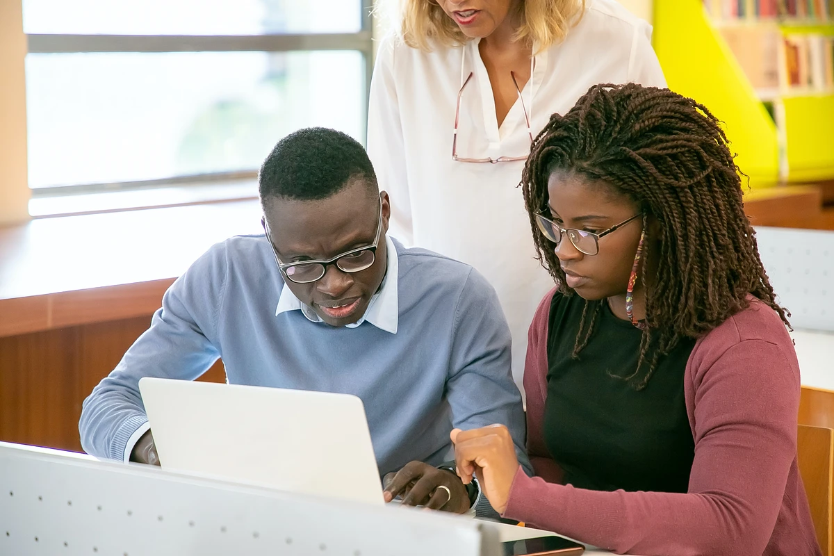 Three people working together with a laptop
